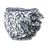 Malina Floral Stoneware Plant Pot in blue, with a rippled, crinkled texture and raised floral and leaf relief on one side, shown on a plain white background.