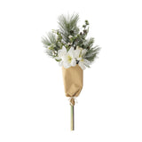 Kristin Artificial Christmas Bouquet in white, with trumpet-shaped blooms, pine needles, small cones and berries wrapped in kraft paper with a twine tie, on a plain white background.