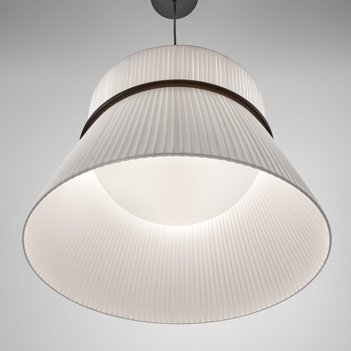 Folie S/60 Ribbon Tiered Pendant Light in White, a two-tier pleated ribbon shade with a slim dark ring at the join, glowing softly against a plain light grey background.