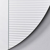 Close-up of the fluted section meeting the plain mirror, the ribs stopping along a curve that follows the outer edge.