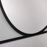 Close-up of the Circo square wall mirror's black frameless edge, showing a printed circular design in mirrored glass against a light grey wall.