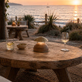 Bell LED Wooden Rechargeable Outdoor Table Lamp IP45 with domed brass-coloured metal shade and wood base, glowing warmly on a rustic table during an outdoor sunset dining setting.