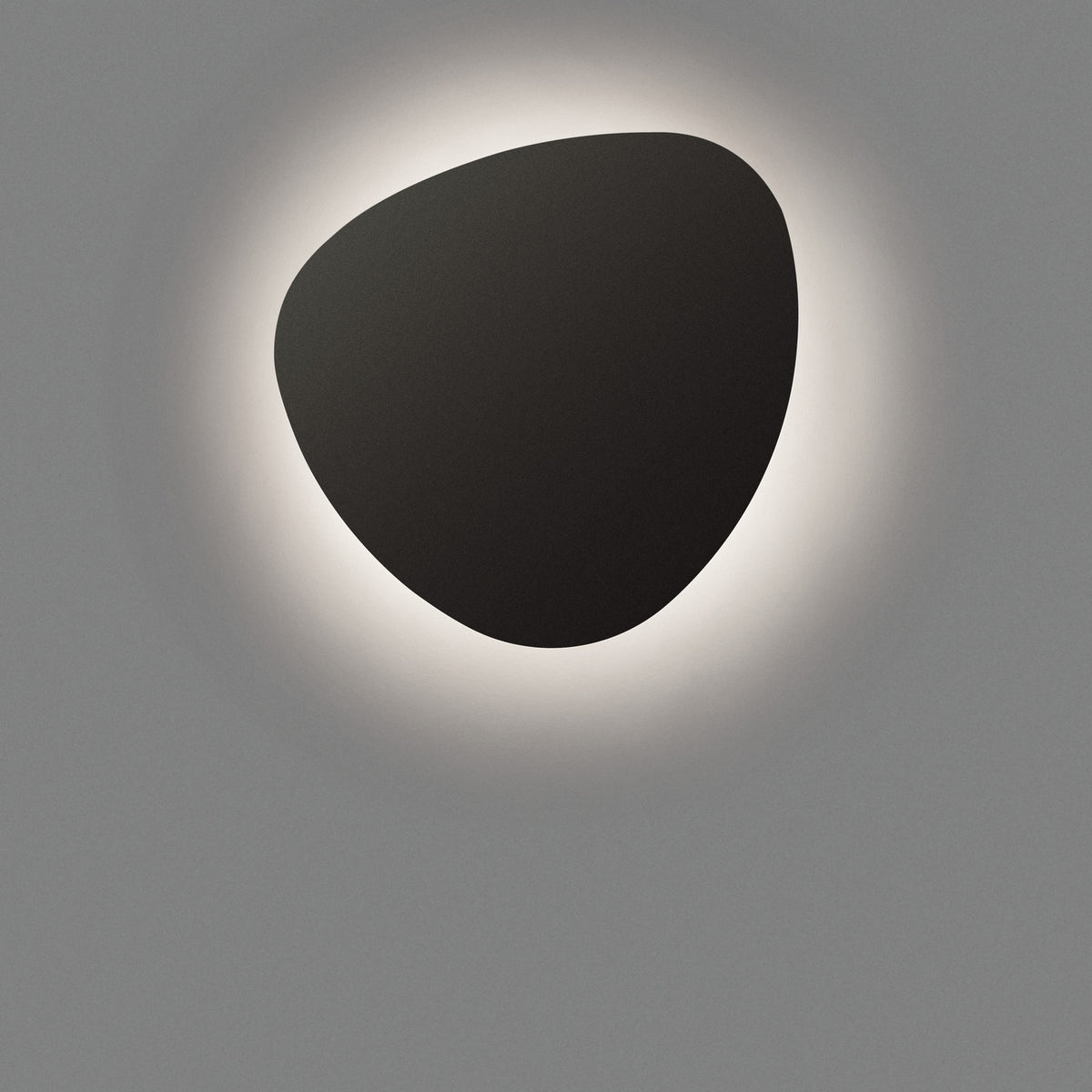 Tria 05 Wood LED Outdoor Wall Light in Graphite Brown Metal, a smooth pebble-shaped fixture casting a soft halo of warm light against a plain grey background.