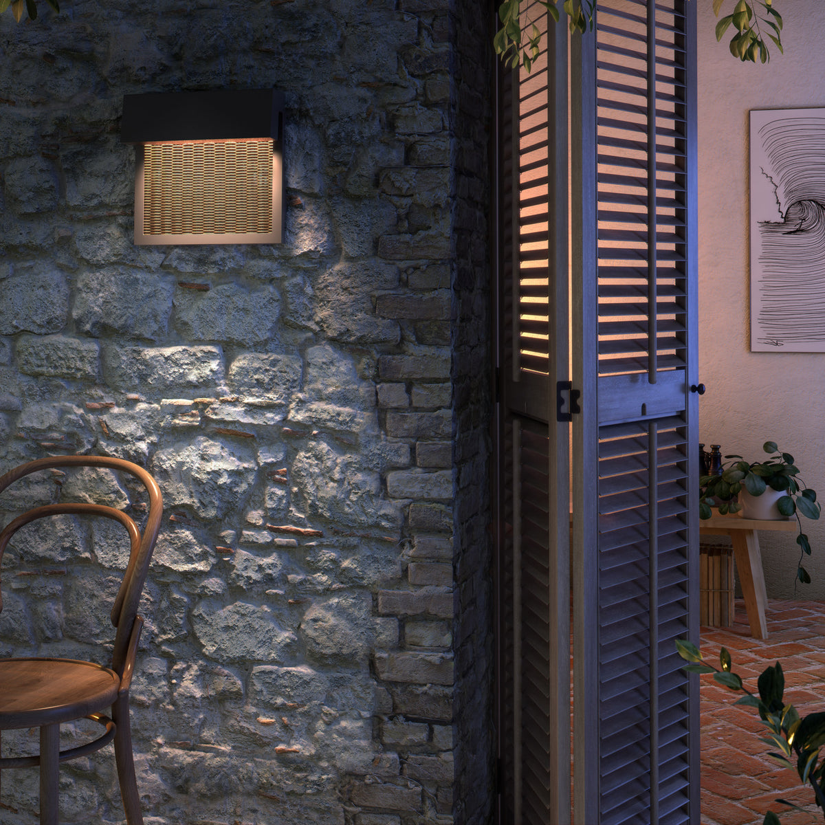 Sisal A/01 LED outdoor wall light with dark overhanging top and woven light beige fibre front, mounted on a stone wall illuminating an outdoor seating area at dusk.