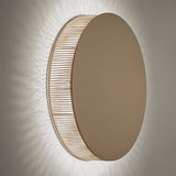 Helios A/02 round wall light with flat oak brown disc face and beige cotton thread edge, integrated warm white LED casting a soft glow on a plain grey wall.