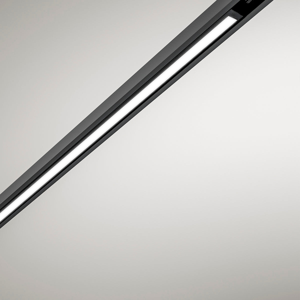Close-up of the Street Line Linear LED Track Spotlight in black, showing a slim bar with a continuous illuminated white diffuser strip, set against a plain light background.