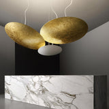Gong Aluminium Disc LED Pendant Light 60cm, two large gold leaf discs and a white oval diffuser suspended above a marble reception counter in a grey interior.