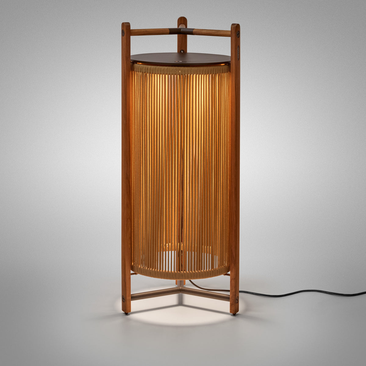 Kando P/111 outdoor floor lamp, a lantern-style cylinder of sand nautical cord within a teak wood frame, dark brown top disc, integrated LED glow, on a plain light grey background.