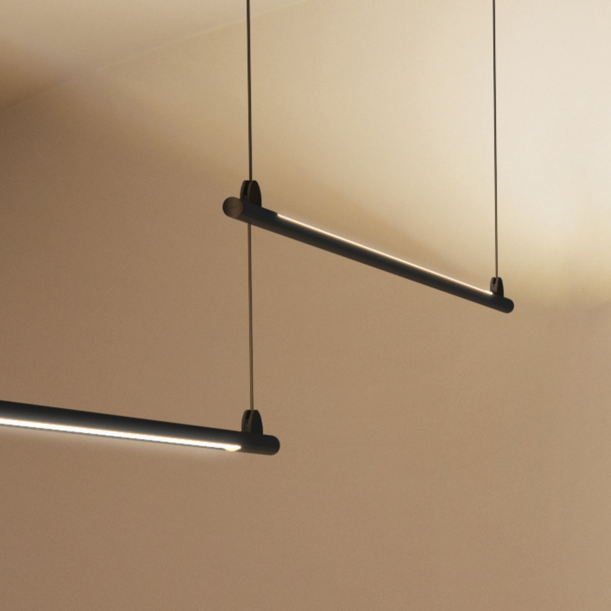 BIMU S150 Dep linear LED pendant lights in matte black, slim tube design suspended on fine cables, shown at an angle against a warm neutral wall.