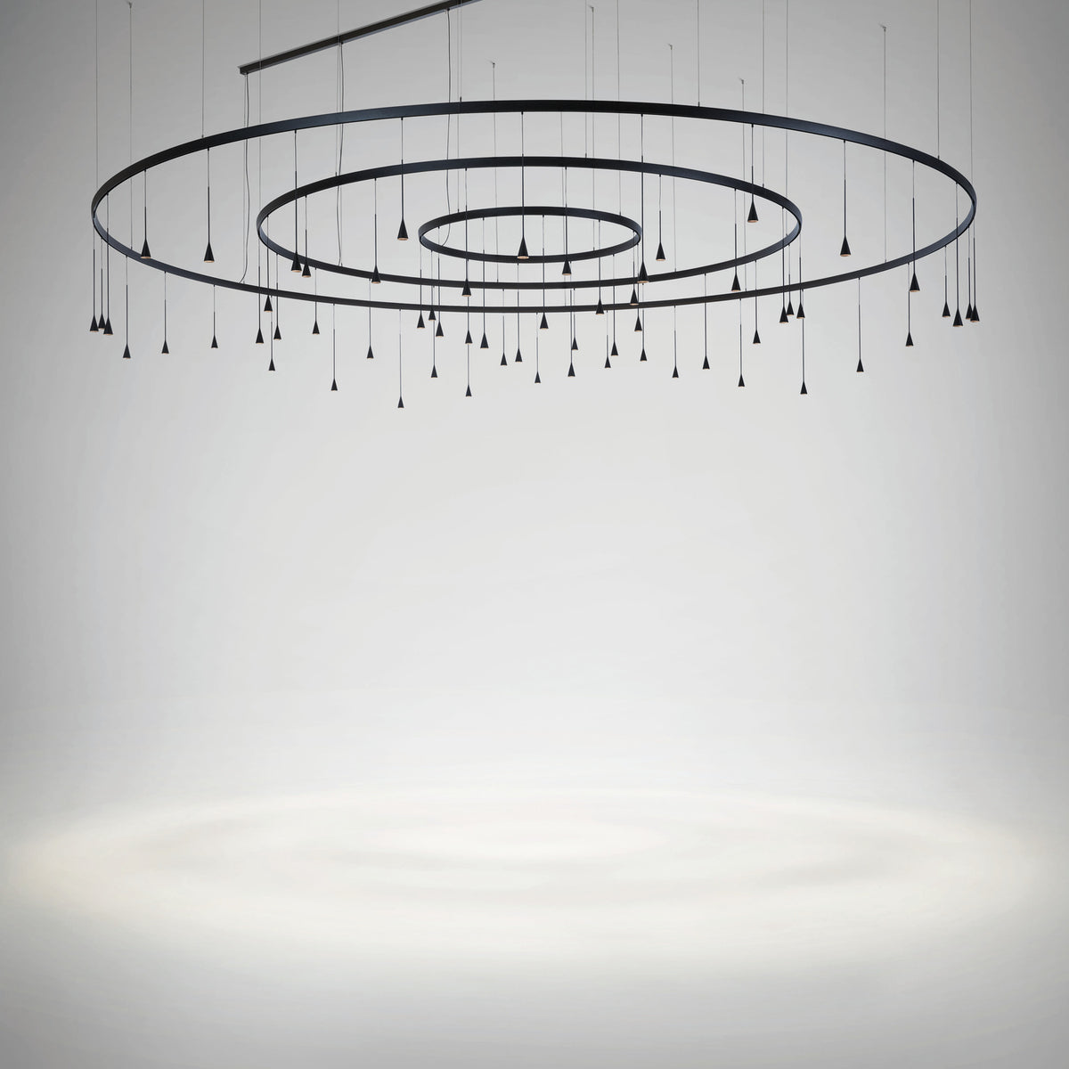 Skybell Circle Iron Ring LED Pendant Light in Ebony Black, with three concentric rings and multiple cone-shaped heads on slim hanging stems, shown against a plain light grey background.