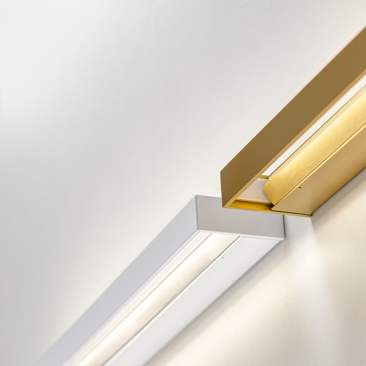 Zero Line Metal Linear LED Wall Light 52cm in white and brushed gold, slim angled bars with warm white light glowing along one recessed edge.