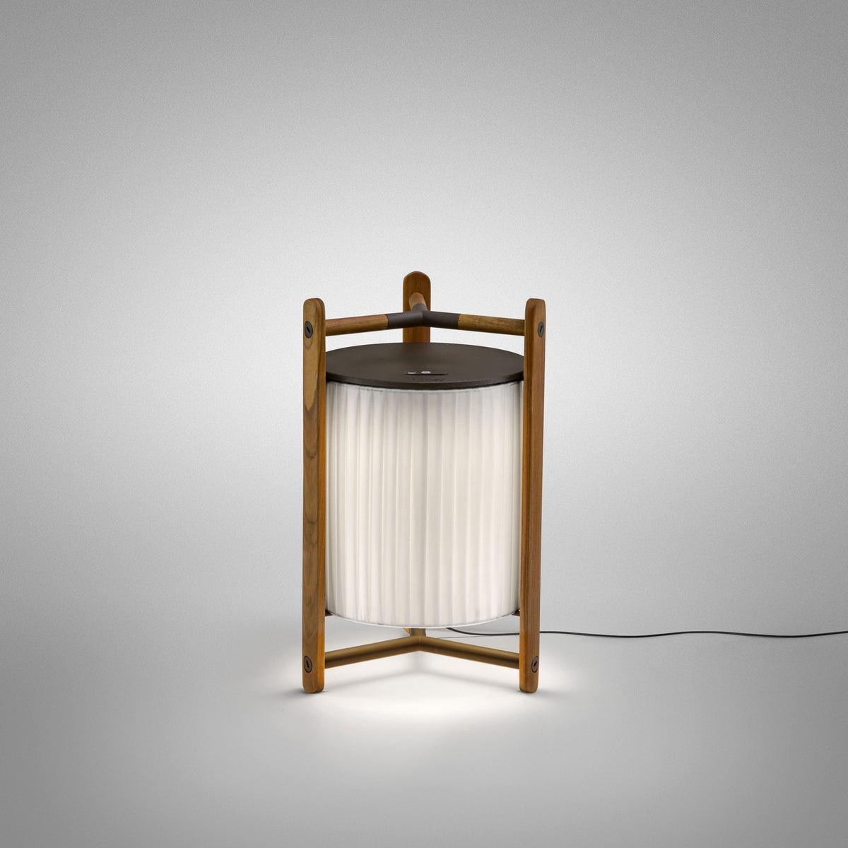 Kando M/40 Ribbon LED table lamp, lantern-style with pleated white translucent shade in an open wood frame with dark top disc, illuminated on a plain light grey background.