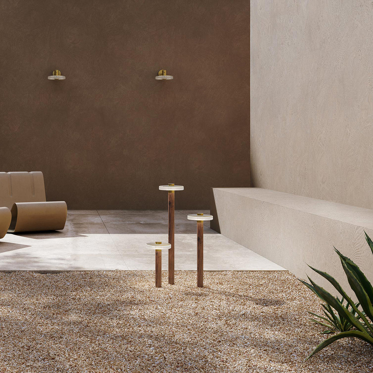 Venexia Glass LED Outdoor Floor Lamp in Wood & Matt Brass, round glass heads on slim wood columns of varying heights, set on gravel in an outdoor courtyard.