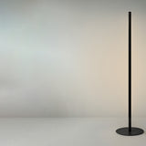 Solid F 240 Cylinder LED Floor Lamp in matte black, a slim stem with a continuous lit line on a round disc base, shown against a plain light background.