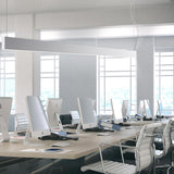 Giano Aluminium Linear LED Pendant Light in white, a slim 151.8cm bar fixture suspended above a modern office desk with monitors and white chairs.