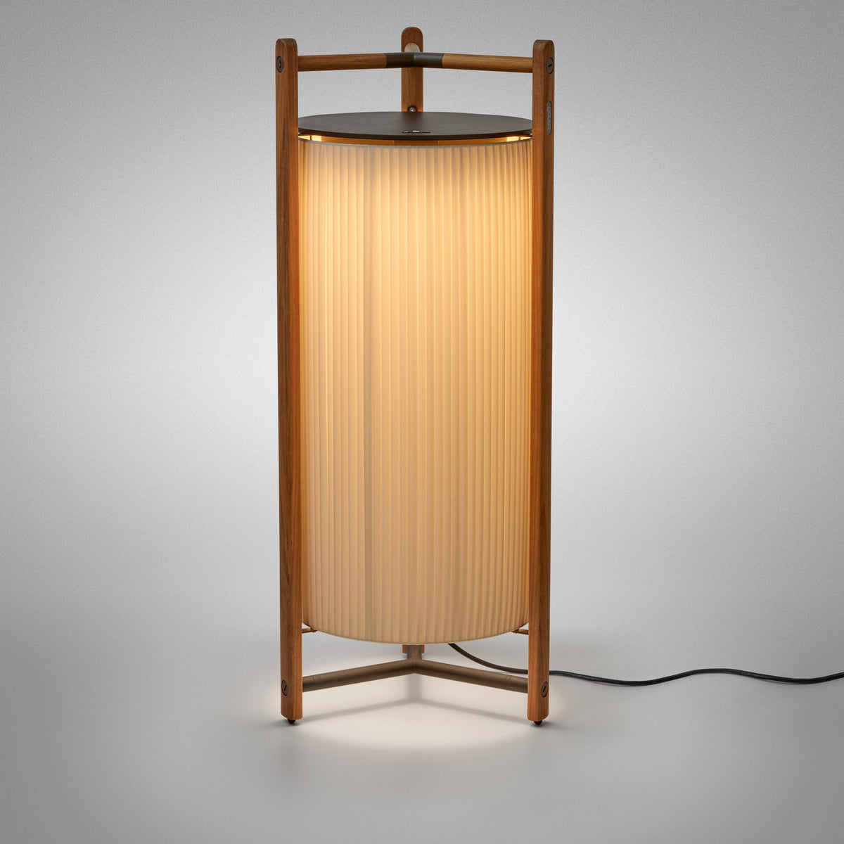 Kando P/111 Ribbon LED floor lamp with a tall pleated white cylinder shade inside a wood three-legged frame and dark top disc, lit against a plain light grey background.
