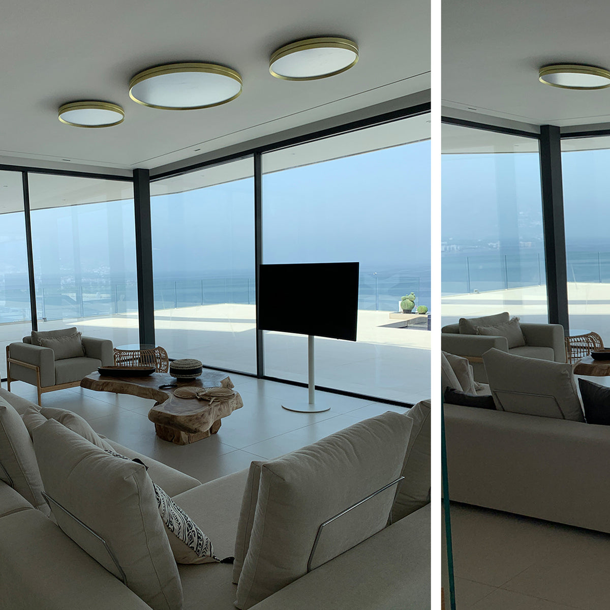 Lite Hole C 120 Aluminium LED ceiling lights in gold-trimmed white finish, mounted in a cluster of three above a bright living room with sofa, TV, and sea view.