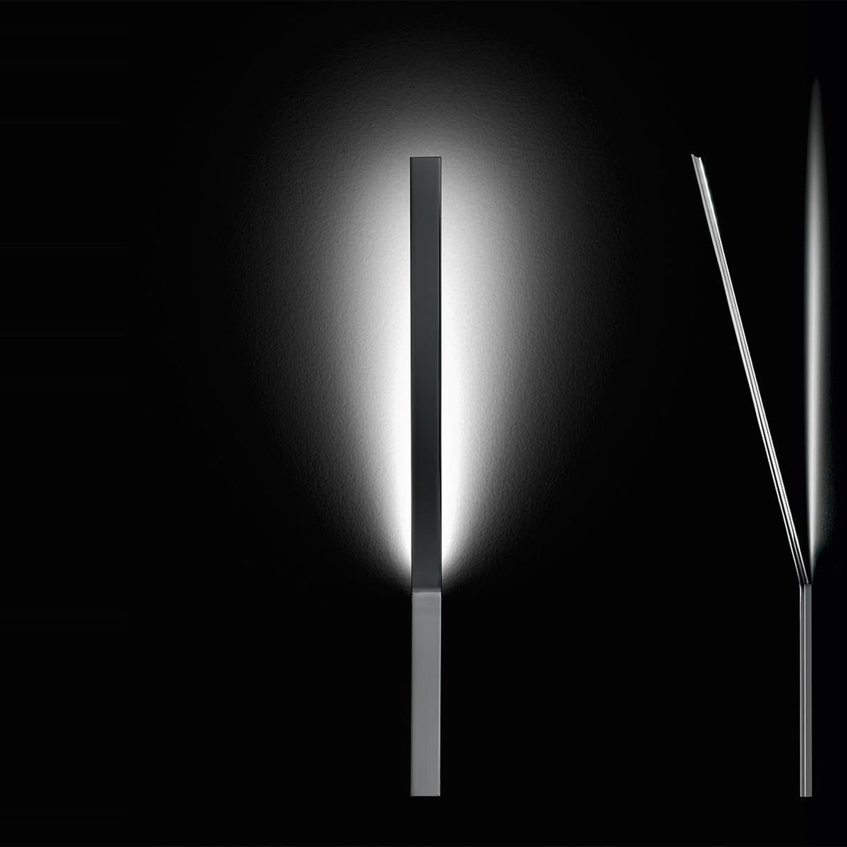 Ypsilon LED wall light in chrome, a slim vertical blade casting soft ambient glow, shown beside a slender angled profile view on a black background.