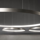 Close-up of the Zero Round Aluminium Ring LED Pendant Light, a slim brushed silver circular fixture with inner-edge illumination, suspended on fine wires against a grey background.