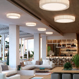 Urban PF/60 Ribbon LED ceiling lights in white, round drum shades with pleated translucent ribbon sides, fitted flush across a lounge and bar ceiling.