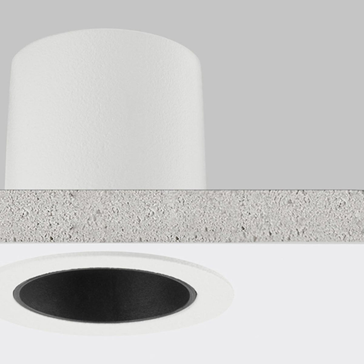 Close-up of the Nick round recessed LED downlight in white, showing the aluminium housing, ceiling cutout, and black interior ring against a plain grey background.