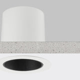 Close-up of the Nick round recessed LED downlight in white, showing the aluminium housing, ceiling cutout, and black interior ring against a plain grey background.