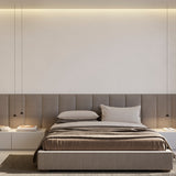 Three slim matt black cone pendant lights, including the Rendez-vous, hang on fine cables above a bed with grey upholstered headboard in a bedroom setting.