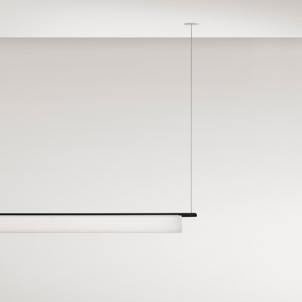 Ombra Fabric LED Pendant Light, 165.2cm long cylindrical off-white diffuser on a black top rail, suspended from a single cable against a plain white ceiling and wall.
