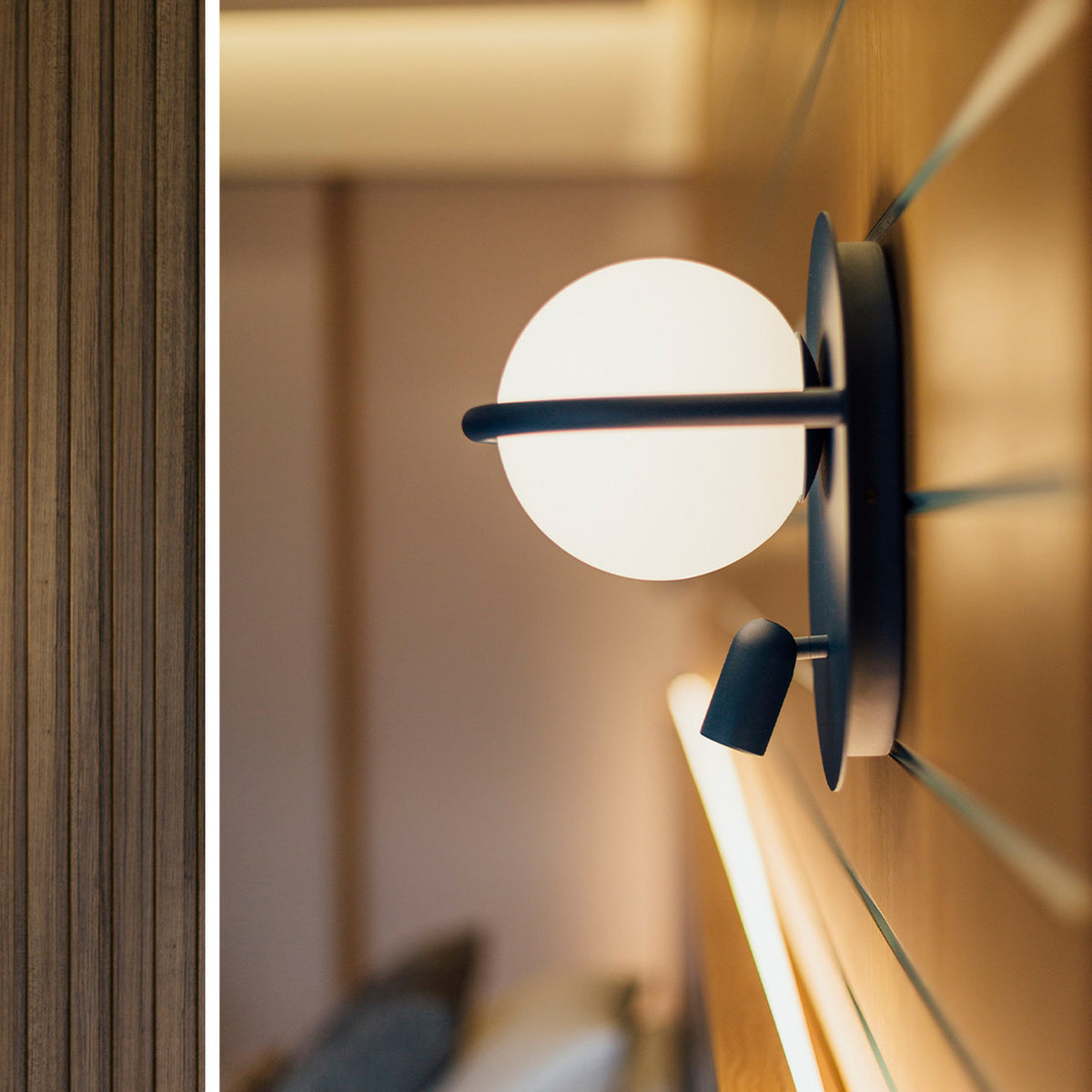 C-Ball W 2 Light Glass Sphere Wall Light in black finish, with a white glass sphere on a slim ring and a small reading spotlight, mounted on a wood-panelled wall.