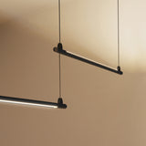 BIMU S200 Ele linear LED pendant light in matte black, slim bar suspended on thin wires, two fixtures shown emitting warm white light against a neutral ceiling.