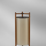 Kando P/111/R rechargeable floor lamp with pleated cream translucent ribbon shade, dark brown top disc, and wooden frame, shown against a plain grey background.