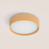 Bloom LED Wood Drum Flush Light in ash, a round ceiling or wall fixture with a shallow wood band framing a white diffuser, shown on a plain light background.