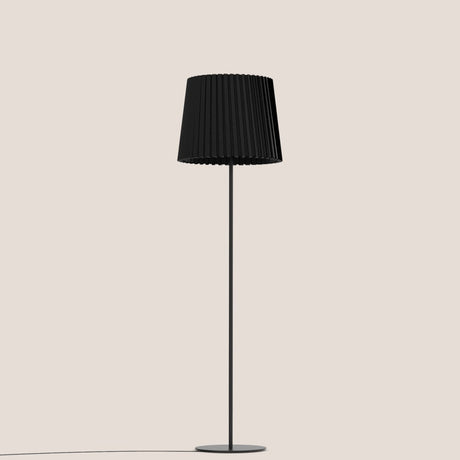 Kilma Ribbed Fabric Floor Lamp in matt black, featuring a pleated tapered fabric shade on a slim iron stem with round flat base, shown on a plain light background.