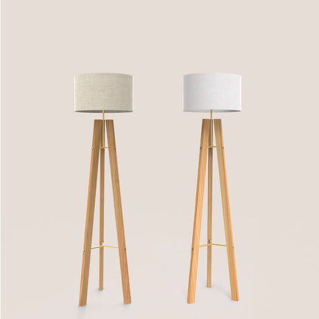 Breeze Fabric Drum Tripod Floor Lamp in gold, shown in two linen shade shades beside a matching light grey version, both with wooden tripod legs on a plain background.