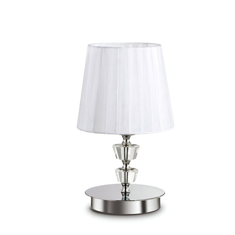 The Solum Small Crystal Table Lamp - White embodies modern sophistication with its white fabric shade and silver metal base, highlighted by a crystal accent beneath the shade. Its sleek and elegant design, standing on a flat circular platform, adds an aura of refined lighting to any space.