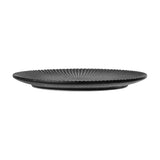 Neri Stoneware Plate in black, shown side-on, revealing a ridged, fluted edge and low profile against a plain white background.