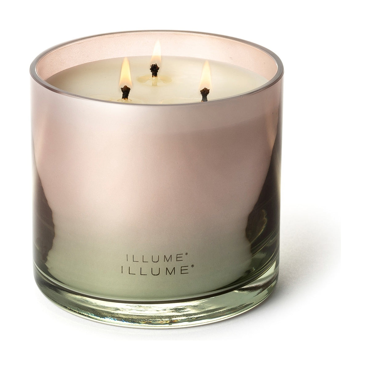Coconut Milk Mango scented candle in a glossy ombré glass vessel shading from pink to green, lit with three cotton wicks, shown on a plain white background.