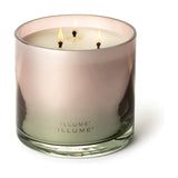 Coconut Milk Mango scented candle in a glossy ombré glass vessel shading from pink to green, lit with three cotton wicks, shown on a plain white background.