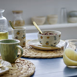 Agnes Stoneware Kids Dinner Set of 3 in cream, patterned plate, bowl and cup with fruit and nature motifs, shown on a table with gold cutlery and woven mats.