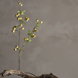 Hawthorn Artificial Branch in yellow, a slender faux stem with clustered round berries and small pointed leaves, set in driftwood against a plain grey background.