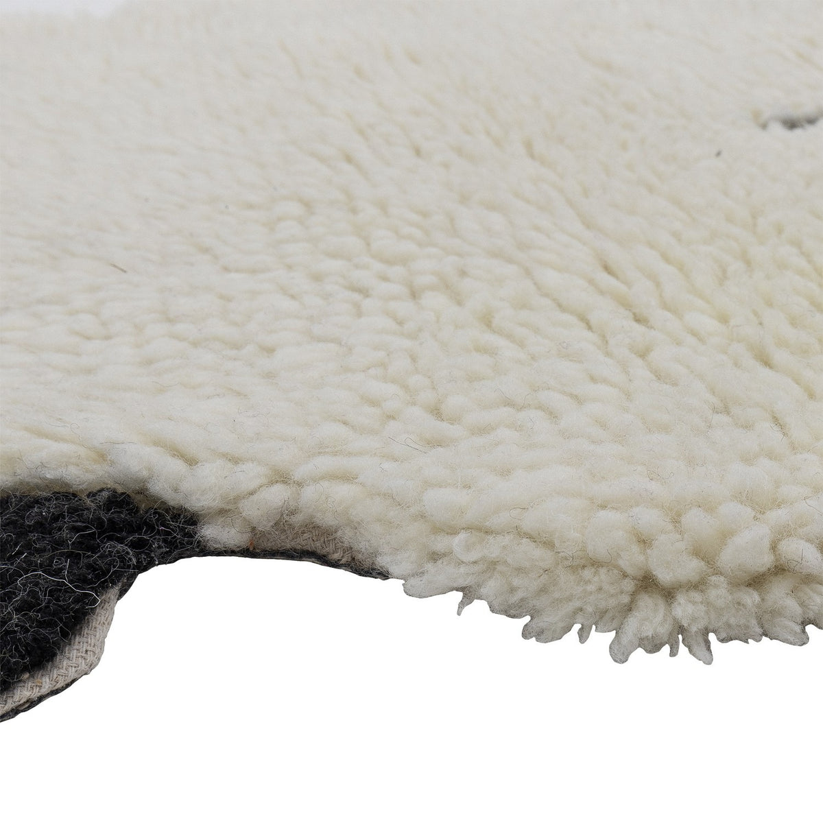 Close-up of the Dolly Sheep Wool Rug in cream, showing its deep curly wool pile and scalloped fleece-like edge against a plain white background.