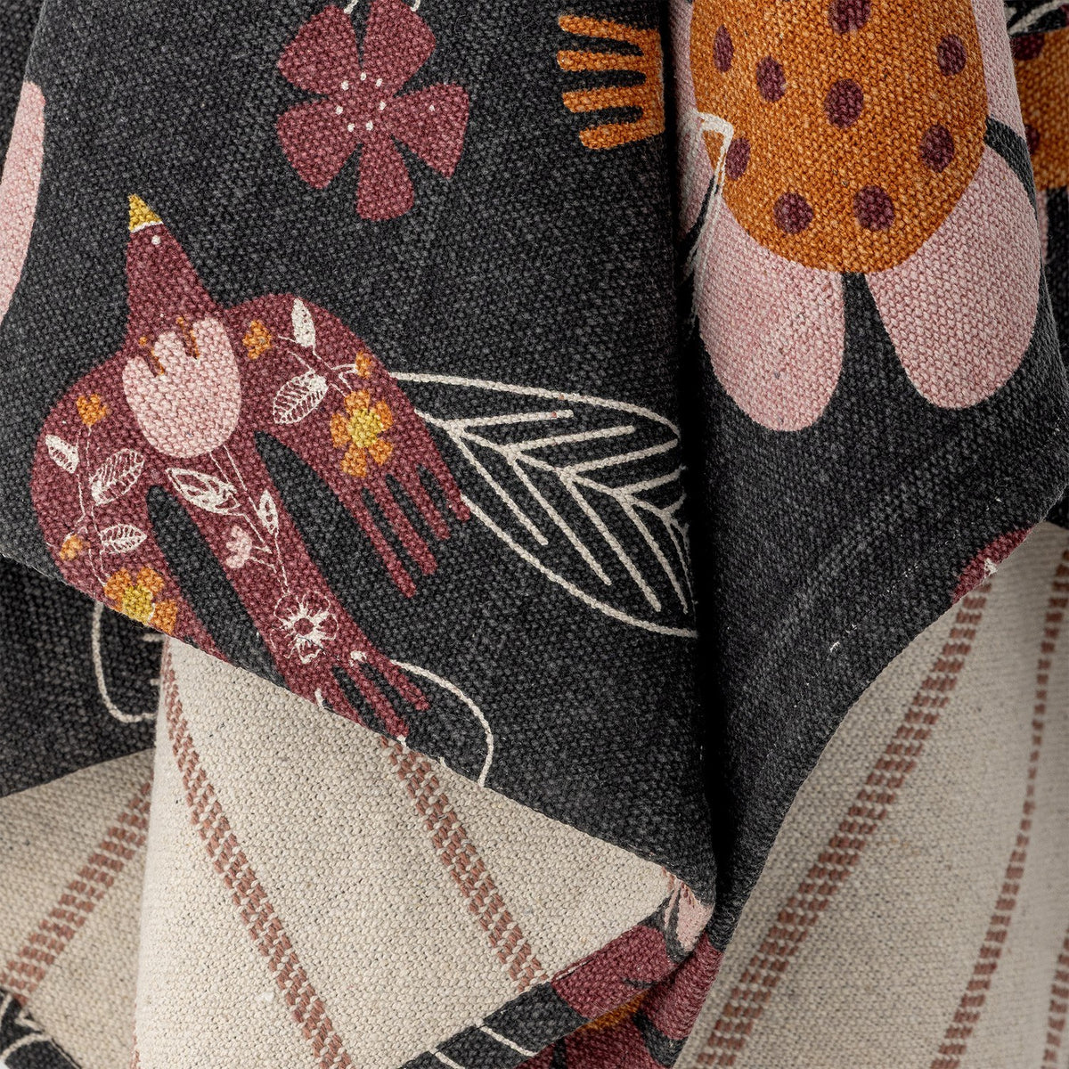 Vivielle Striped Throw in Multi, close-up of fabric folds showing a dark floral side with birds and blooms against a beige striped reverse.