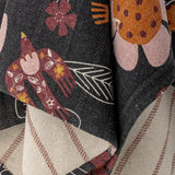 Vivielle Striped Throw in Multi, close-up of fabric folds showing a dark floral side with birds and blooms against a beige striped reverse.