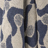 Close-up of the Santena Wavy Cotton Throw in blue, showing a woven cotton textured surface with a wavy pattern and small dotted circles.
