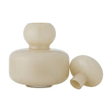 Cynthia Glass Vase 21cm in Beige, glossy mouth-blown glass with a rounded body, ball-shaped neck and domed mushroom-style stopper shown beside it, on a plain white background.