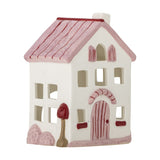 Shirly House stoneware tealight holder in white, shaped like a cottage with a pink pitched roof, chimney, cut-out windows and a hand-painted arched front door, on a plain white background.