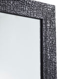 Close-up of the charred black frame at an angle, the crackled surface running the length of the timber edge.