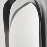 Close-up of the top curve, the black frame turning away from the wall as it rises around the oval glass.