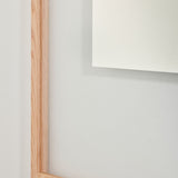 Close-up of the oak frame edge and the transparent border, showing where the mirrored centre begins.