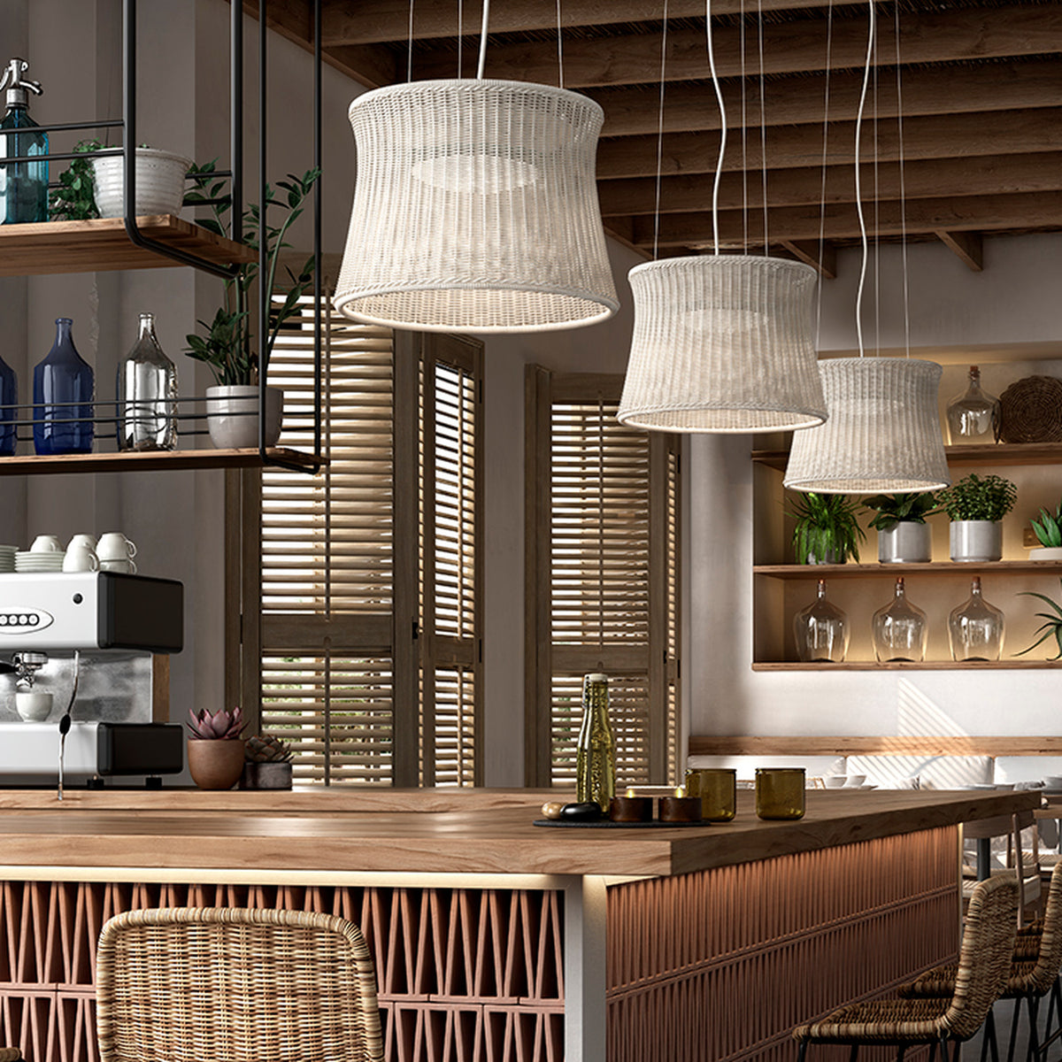 Syra 45 Aluminium LED pendant lights with woven ivory white drum shades narrowing at the waist, hanging in multiples above a wooden kitchen island.